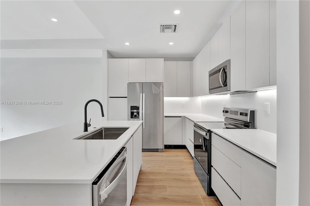 1563 NW 94th Way Unit 09, Coral Springs, FL 33071 - kitchen featuring appliances with stainless steel finishes, modern cabinets, recessed lighting, light countertops, and light wood-type flooring