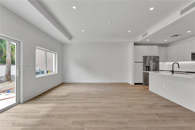1563 NW 94th Way Unit 09, Coral Springs, FL 33071 - unfurnished living room with recessed lighting, light wood-style floors, and a raised ceiling