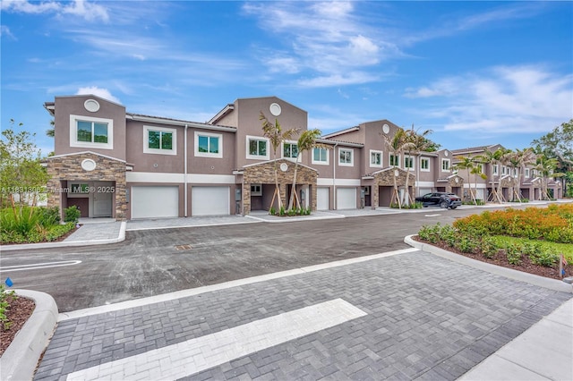1563 NW 94th Way Unit 09, Coral Springs, FL 33071 - view of front of home featuring stucco siding, stone siding, an attached garage, and a residential view