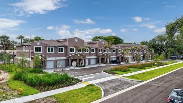 1563 NW 94th Way Unit 09, Coral Springs, FL 33071 - view of property's community with an attached garage, asphalt driveway, and a residential view