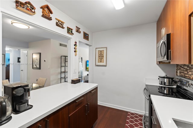 1700 NE 105th St Unit 312, Miami Shores, FL 33138 - kitchen featuring electric range oven, stainless steel microwave, dark wood-type flooring, light countertops, and backsplash