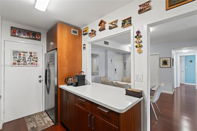 1700 NE 105th St Unit 312, Miami Shores, FL 33138 - kitchen with freestanding refrigerator, a peninsula, dark wood-style flooring, and light countertops