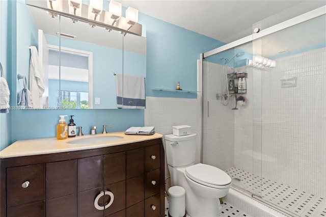 1700 NE 105th St Unit 312, Miami Shores, FL 33138 - bathroom featuring a shower stall, vanity, tile walls, a wainscoted wall, and tile patterned floors
