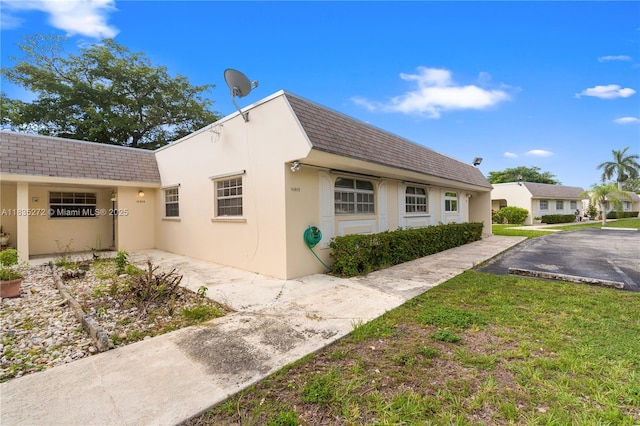 16805 SW 113th Ave Unit V41443, Miami, FL 33157 - view of side of home with stucco siding, a shingled roof, and mansard roof