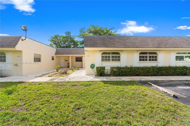 16805 SW 113th Ave Unit V41443, Miami, FL 33157 - view of front of home featuring a front yard, stucco siding, roof with shingles, and mansard roof