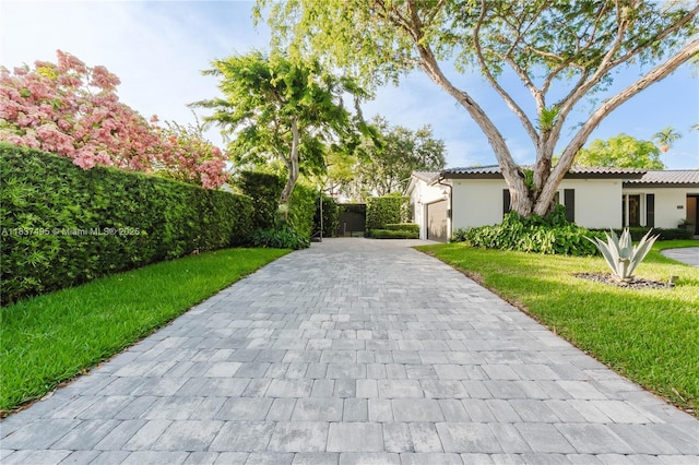 8501 SW 72nd Ter, Miami, FL 33143 - view of front facade featuring decorative driveway, stucco siding, a garage, and a front lawn