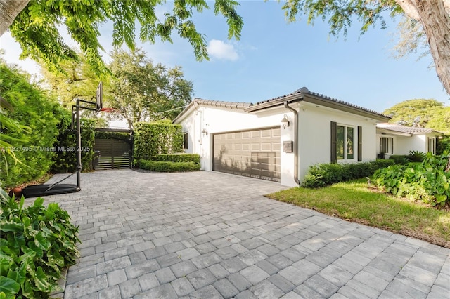 8501 SW 72nd Ter, Miami, FL 33143 - view of property exterior with an attached garage, stucco siding, decorative driveway, and a tiled roof