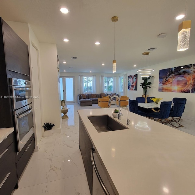 10440 NW 67th St Unit 10440, Doral, FL 33178 - kitchen with light countertops, recessed lighting, light marble finish flooring, modern cabinets, and stainless steel double oven