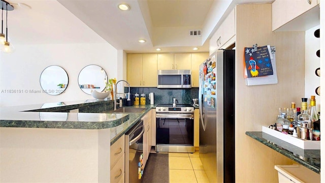 5600 Collins Ave Unit 10A, Miami Beach, FL 33140 - kitchen featuring stainless steel appliances, recessed lighting, light tile patterned flooring, a peninsula, and dark stone counters