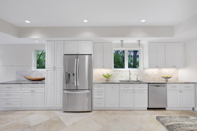 315 E Rivo Alto Dr, Miami Beach, FL 33139 - kitchen with appliances with stainless steel finishes, stone counters, white cabinetry, tasteful backsplash, and recessed lighting