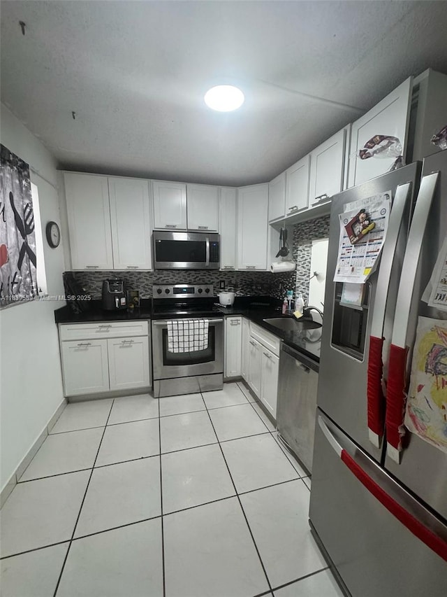 17000 NW 67th Ave Unit 206, Hialeah, FL 33015 - kitchen with appliances with stainless steel finishes, tasteful backsplash, dark countertops, and light tile patterned floors