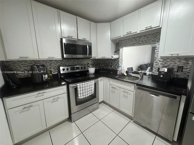 17000 NW 67th Ave Unit 206, Hialeah, FL 33015 - kitchen featuring stainless steel appliances, light tile patterned flooring, dark countertops, and white cabinets