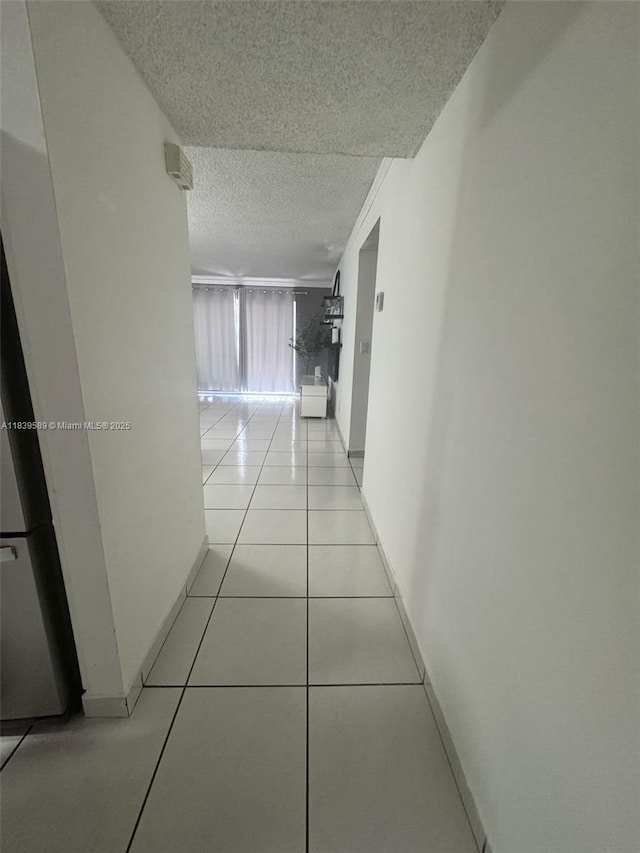17000 NW 67th Ave Unit 206, Hialeah, FL 33015 - hallway featuring a textured ceiling and light tile patterned flooring