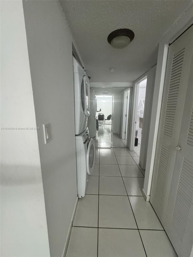 17000 NW 67th Ave Unit 206, Hialeah, FL 33015 - hall with stacked washer / dryer, light tile patterned floors, and a textured ceiling