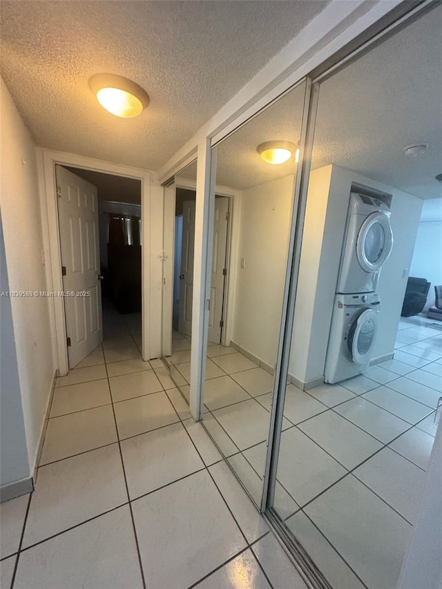 17000 NW 67th Ave Unit 206, Hialeah, FL 33015 - hall with stacked washing machine and dryer, a textured ceiling, and light tile patterned flooring
