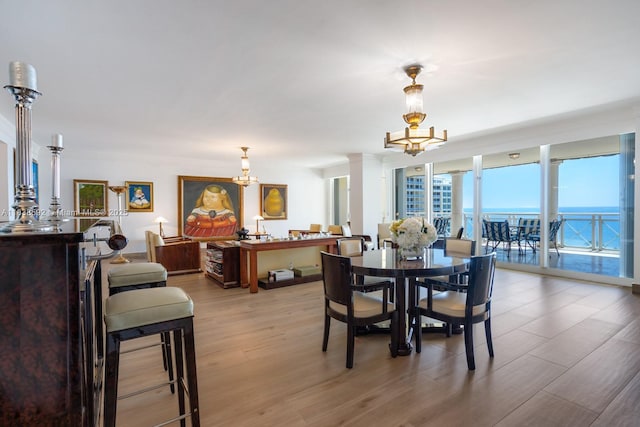 445 Grand Bay Dr Unit 1011, Key Biscayne, FL 33149 - dining area featuring a chandelier, plenty of natural light, wood finished floors, and a wall of windows
