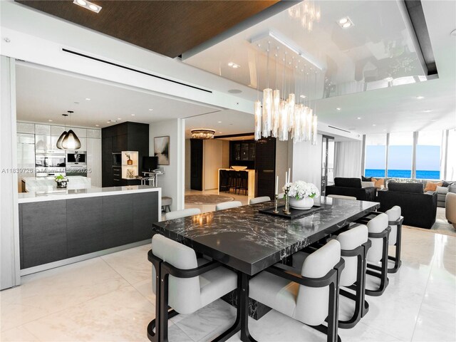 17475 Collins Ave Unit 1001, Sunny Isles Beach, FL 33160 - dining space featuring light marble finish flooring, recessed lighting, a chandelier, and a water view