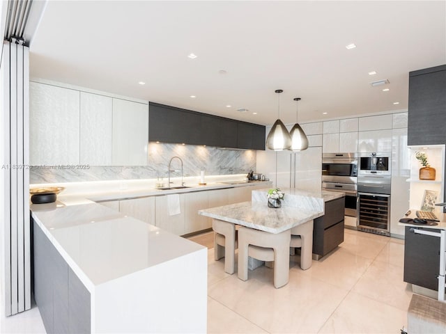 17475 Collins Ave Unit 1001, Sunny Isles Beach, FL 33160 - kitchen featuring modern cabinets, beverage cooler, tasteful backsplash, a center island, and decorative light fixtures