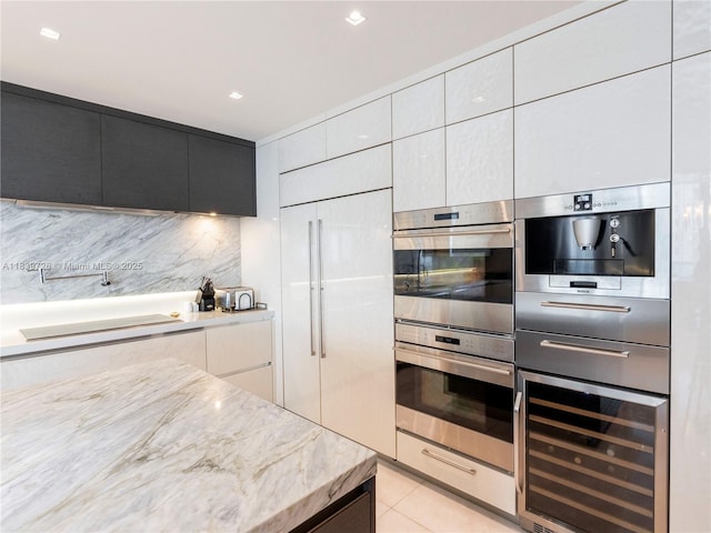 17475 Collins Ave Unit 1001, Sunny Isles Beach, FL 33160 - kitchen featuring wine cooler, stainless steel double oven, modern cabinets, light stone counters, and tasteful backsplash