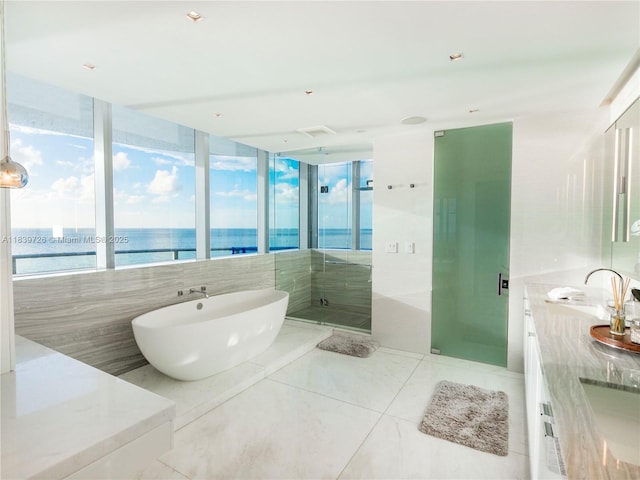 17475 Collins Ave Unit 1001, Sunny Isles Beach, FL 33160 - full bathroom featuring double vanity, a freestanding bath, a stall shower, a water view, and tile patterned flooring