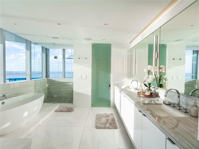 17475 Collins Ave Unit 1001, Sunny Isles Beach, FL 33160 - full bathroom featuring a freestanding tub, double vanity, a stall shower, and tile patterned flooring