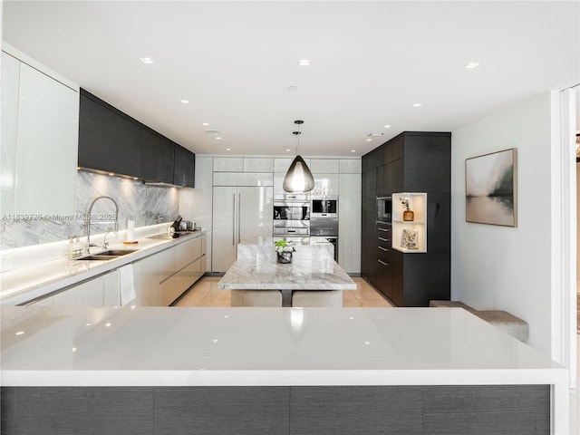 17475 Collins Ave Unit 1001, Sunny Isles Beach, FL 33160 - kitchen with modern cabinets, built in appliances, backsplash, a center island, and decorative light fixtures