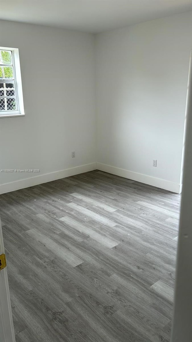 3851 NW 3rd Ter, Deerfield Beach, FL 33064 - empty room with baseboards and dark wood-style flooring