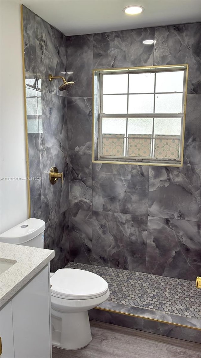 3851 NW 3rd Ter, Deerfield Beach, FL 33064 - bathroom featuring tiled shower, wood finished floors, and vanity