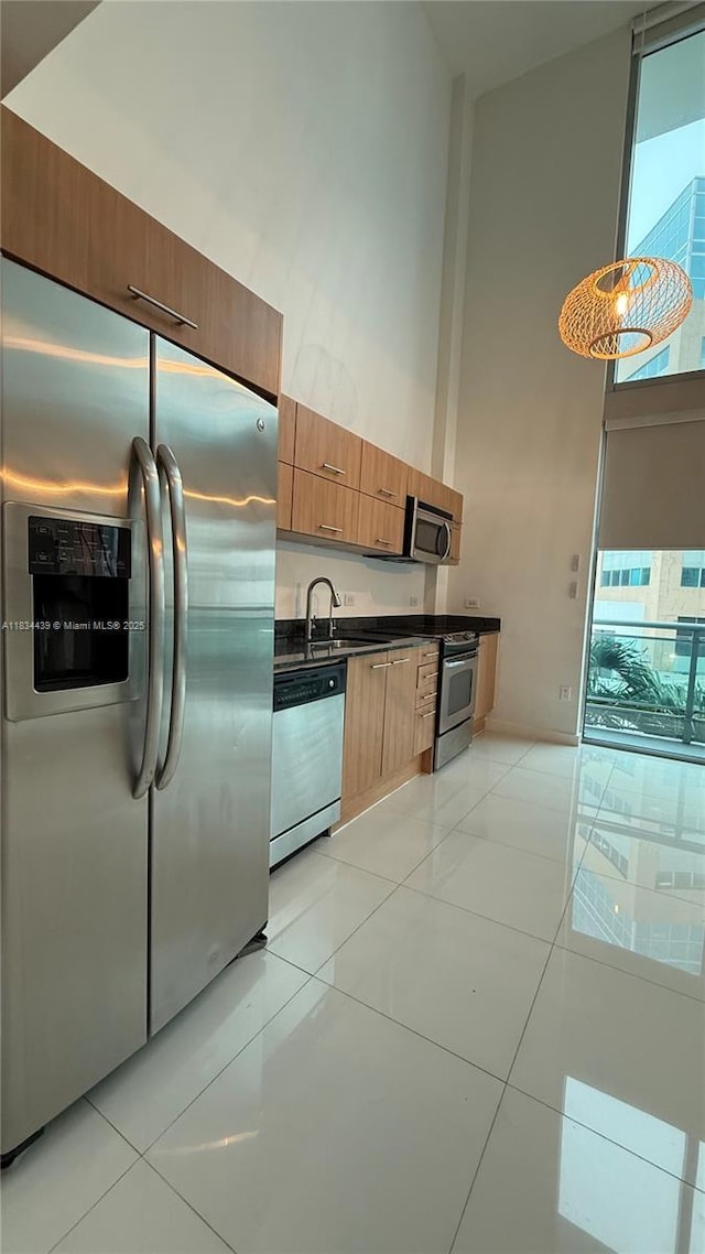 350 S Miami Ave Unit 302, Miami, FL 33130 - kitchen featuring stainless steel appliances, a high ceiling, dark countertops, light tile patterned flooring, and modern cabinets