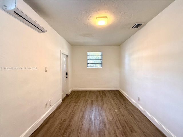 2406 N 28th Ave, Hollywood, FL 33020 - unfurnished room with an AC wall unit, wood finished floors, and a textured ceiling
