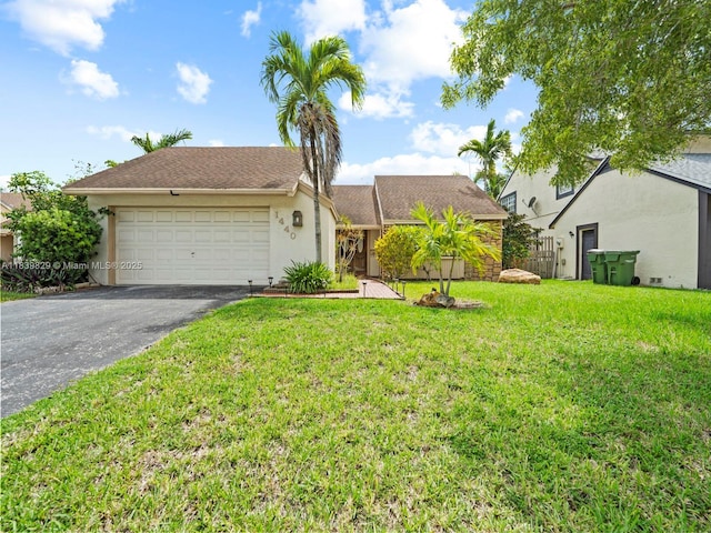 1440 Egret Rd, Homestead, FL 33035 - view of front of house featuring asphalt driveway, stucco siding, a front lawn, and an attached garage