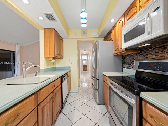 1440 Egret Rd, Homestead, FL 33035 - kitchen featuring white appliances, light countertops, light tile patterned floors, brown cabinetry, and recessed lighting
