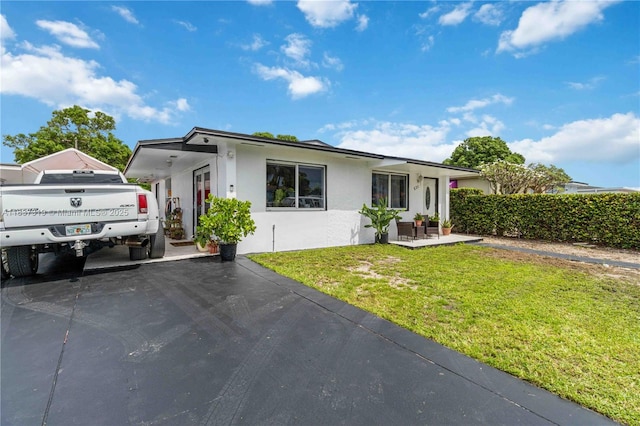 231 E 41st St, Hialeah, FL 33013 - view of front facade with stucco siding, a front yard, and driveway