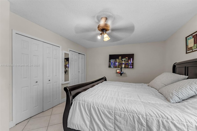 13305 SW 22nd Ter, Miami, FL 33175 - bedroom featuring light tile patterned floors, multiple closets, a ceiling fan, and a textured ceiling