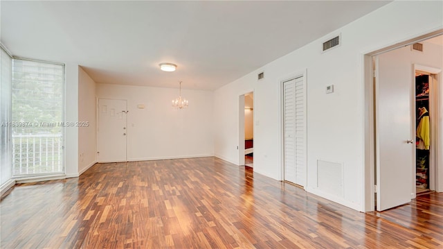 10178 Collins Ave Unit 102, Bal Harbour, FL 33154 - spare room with a chandelier and wood finished floors
