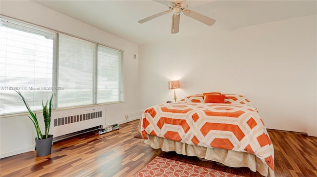 10178 Collins Ave Unit 102, Bal Harbour, FL 33154 - bedroom with radiator, wood finished floors, and a ceiling fan