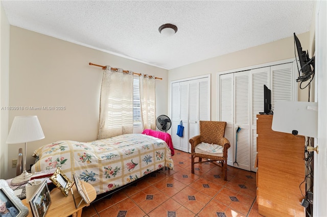 14213 SW 100th Ln, Miami, FL 33186 - bedroom featuring multiple closets, tile patterned flooring, and a textured ceiling