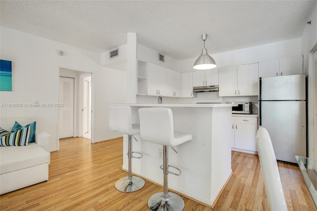 19701 E Country Club Dr Unit 5104, Aventura, FL 33180 - kitchen featuring freestanding refrigerator, white microwave, under cabinet range hood, light wood-style floors, and light countertops