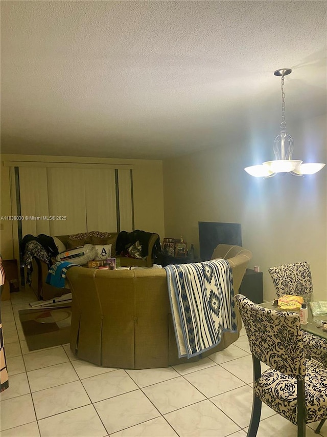 5335 NW 10th Ct Unit 208, Plantation, FL 33313 - living area featuring light tile patterned floors, a textured ceiling, and a chandelier