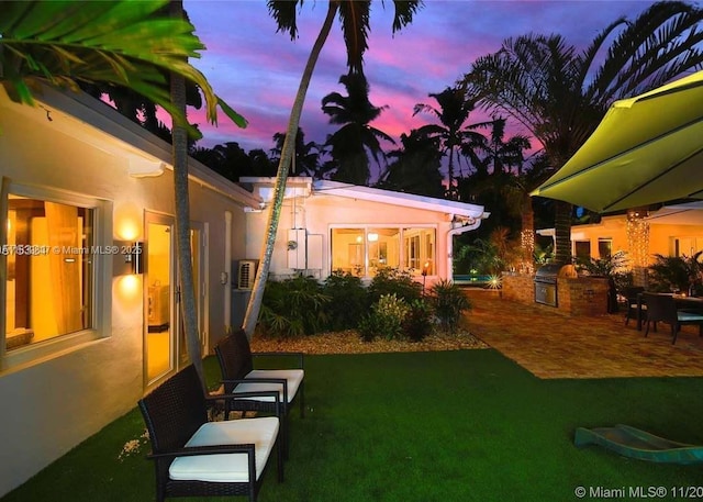 920 NE 72nd St, Miami, FL 33138 - yard at dusk with exterior kitchen, a lawn, and a patio area