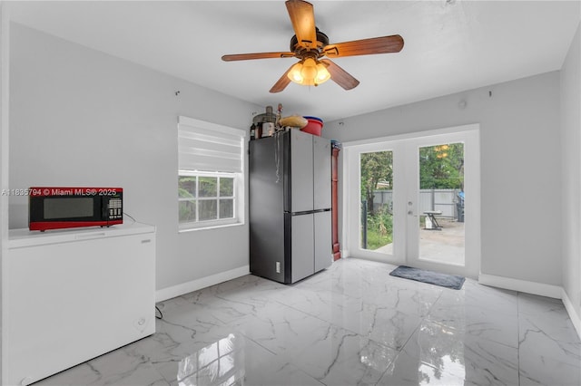 1340 NW 128th St, North Miami, FL 33167 - empty room featuring healthy amount of natural light, french doors, light marble finish floors, and a ceiling fan