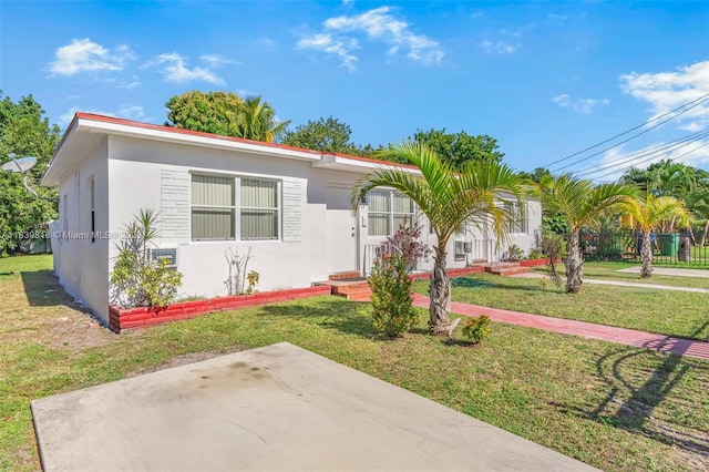 1315 NE 146th St, Miami, FL 33161 - view of front of home featuring a front yard, stucco siding, and a patio