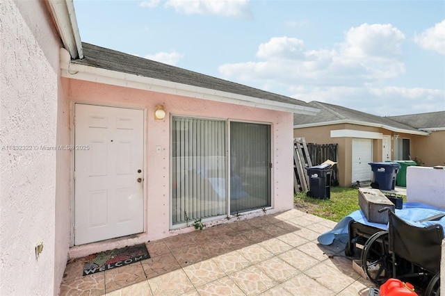 3120 NW 203rd Ter, Miami Gardens, FL 33056 - view of exterior entry featuring stucco siding, a patio area, and roof with shingles