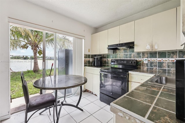 3120 NW 203rd Ter, Miami Gardens, FL 33056 - kitchen with electric range, under cabinet range hood, tasteful backsplash, a textured ceiling, and dark countertops
