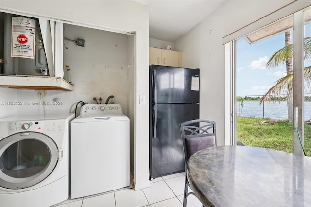 3120 NW 203rd Ter, Miami Gardens, FL 33056 - laundry room featuring a water view, light tile patterned floors, and washing machine and dryer