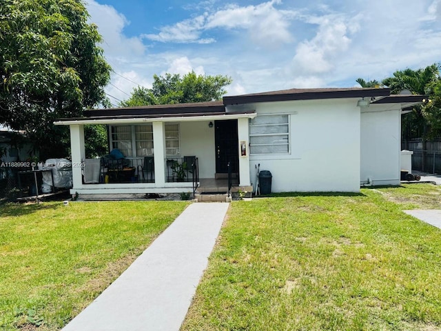 7230 NW 3rd St, Miami, FL 33126 - view of front of home with a front lawn, a porch, and stucco siding