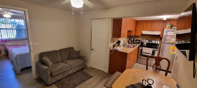 7230 NW 3rd St, Miami, FL 33126 - kitchen with appliances with stainless steel finishes, under cabinet range hood, ceiling fan, light wood finished floors, and light countertops