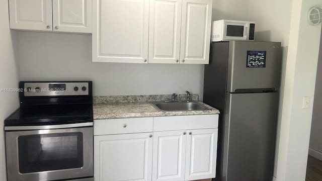 7230 NW 3rd St, Miami, FL 33126 - kitchen with appliances with stainless steel finishes, white cabinetry, and light countertops