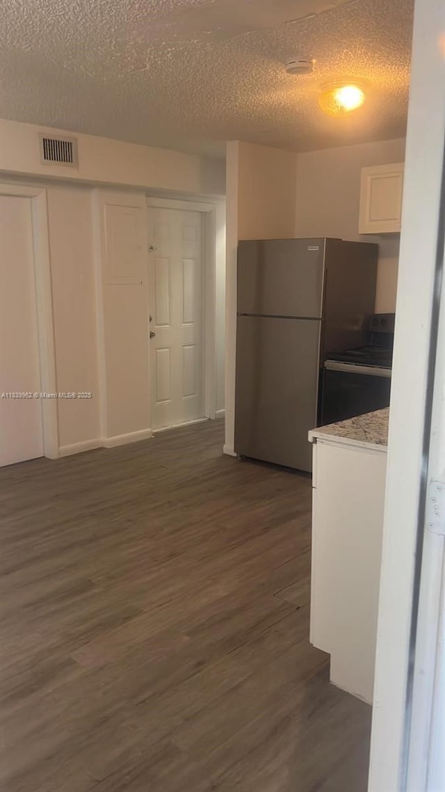 7230 NW 3rd St, Miami, FL 33126 - kitchen with freestanding refrigerator, dark wood finished floors, white cabinetry, a textured ceiling, and light countertops