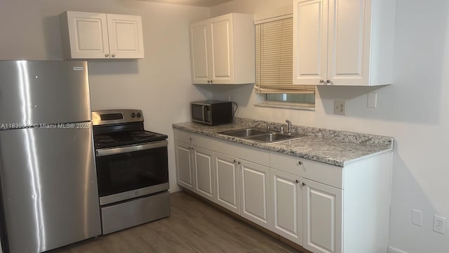 7230 NW 3rd St, Miami, FL 33126 - kitchen with appliances with stainless steel finishes, white cabinets, light countertops, and dark wood-type flooring